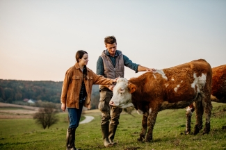 Mujer y hombre acariciando vaca